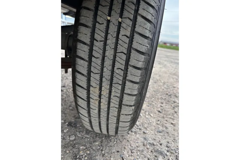 Slide: The Image of Close-up of a tire on a 2015 Tracker Pro Guide V-16 T boat trailer. - 13