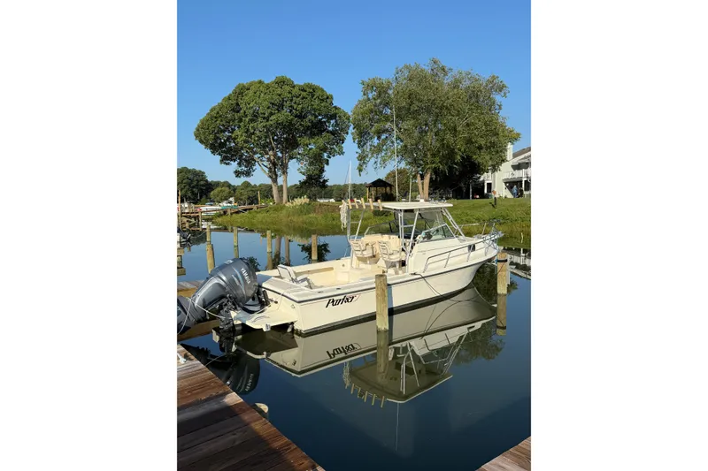 The Image of 2004 Parker 2510 Modified Vee Walkaround boat docked on calm water. - 0