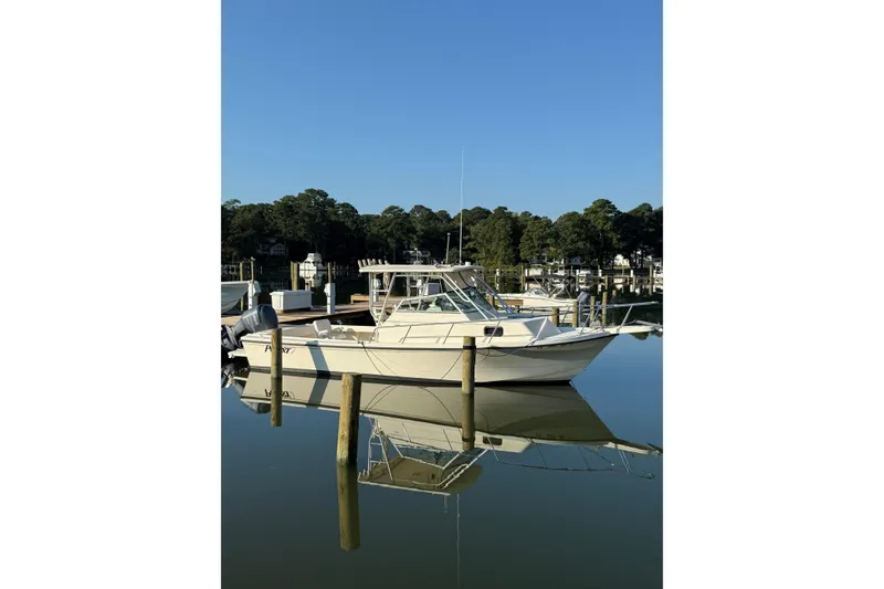 Slide: The Image of 2004 Parker 2510 Modified Vee Walkaround boat docked on calm water. - 3