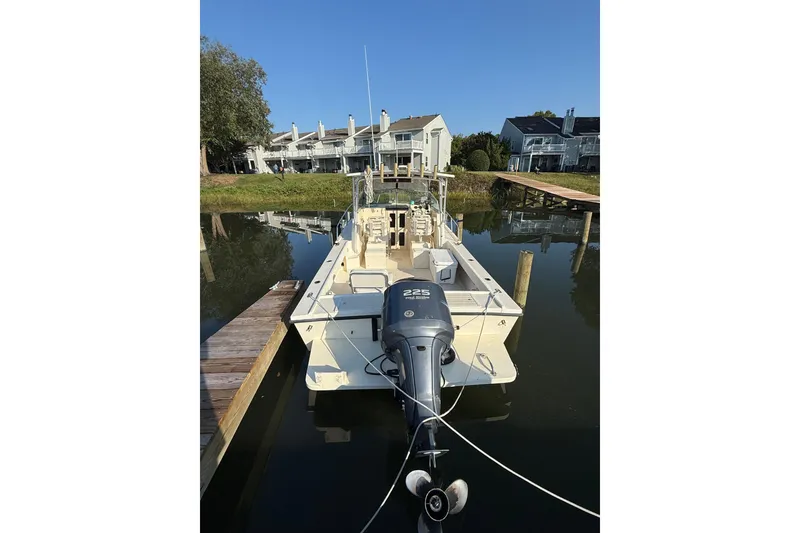 Slide: The Image of 2004 Parker 2510 Modified Vee Walkaround boat docked in calm waters. - 4