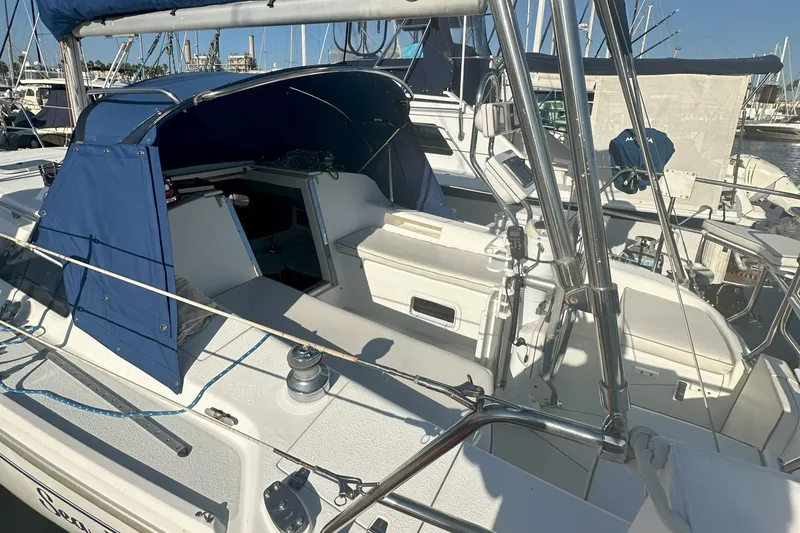 Slide: The Image of 2001 Catalina 28 MkII sailboat with blue canopy, docked in a marina. - 10