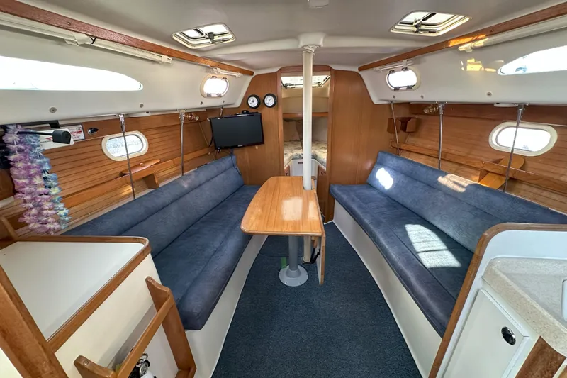 Slide: The Image of Interior of 2001 Catalina 28 MkII sailboat with blue seating and wooden accents. - 14