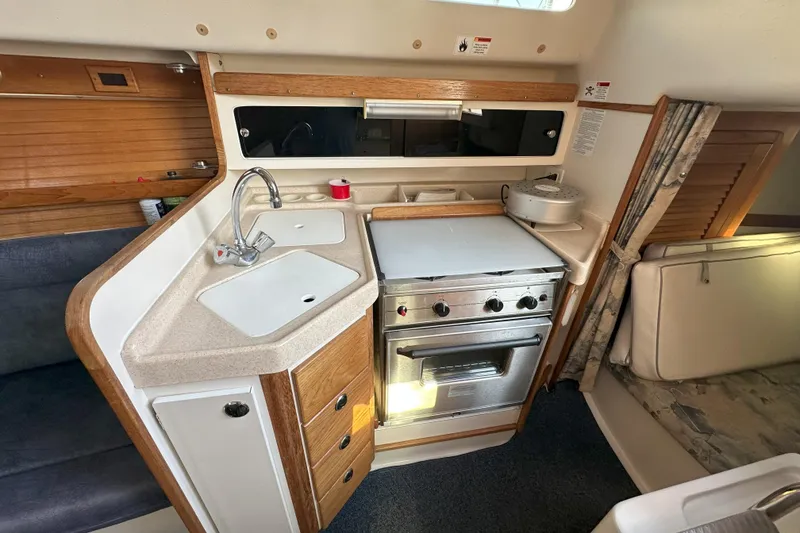 Slide: The Image of Compact kitchen in a 2001 Catalina 28 MkII sailboat with stove, sink, and storage. - 16