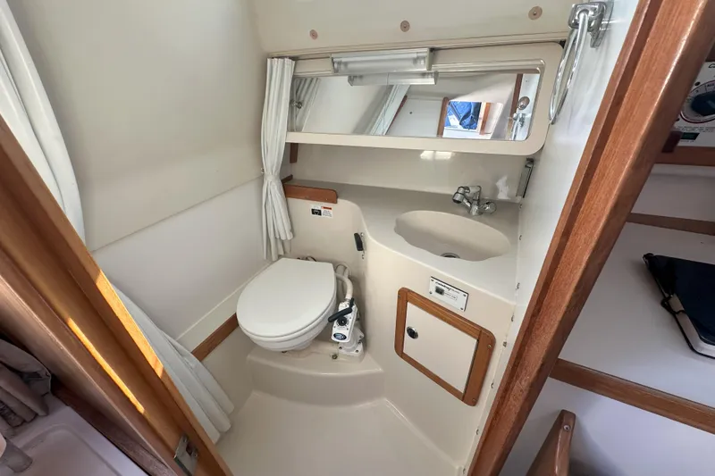 Slide: The Image of 2001 Catalina 28 MkII yacht bathroom with toilet, sink, and mirror. - 17