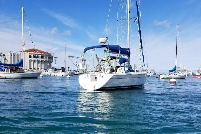 Slide: The Image of 2001 Catalina 28 MkII sailboat anchored in a scenic harbor with clear blue skies. - 2