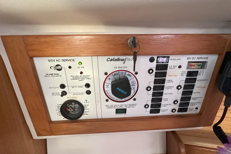 Slide: The Image of Control panel of a 2001 Catalina 28 MkII yacht with AC and DC service switches. - 22