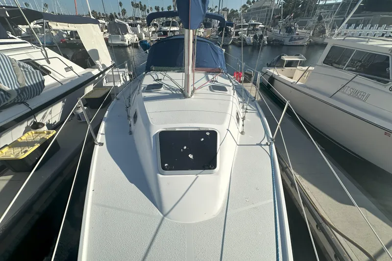 Slide: The Image of 2001 Catalina 28 MkII sailboat docked in a marina, surrounded by other boats. - 7