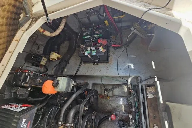 Slide: The Image of Engine compartment of a 2001 Sea Ray 260 Sundancer boat, showing battery and mechanical components. - 13