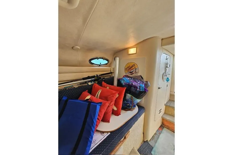 Slide: The Image of Interior of 2001 Sea Ray 260 Sundancer with cushions and bags on a bench. - 17