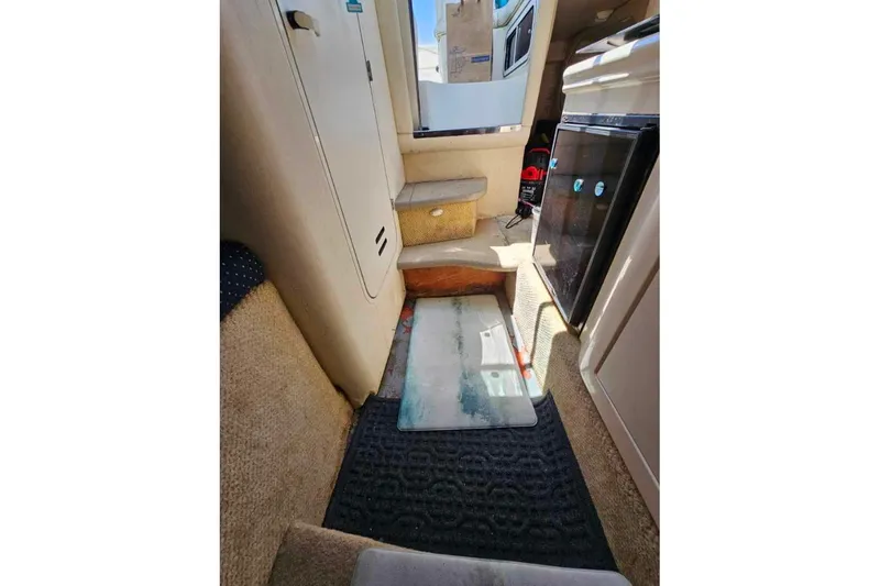 Slide: The Image of Interior of 2001 Sea Ray 260 Sundancer boat, featuring compact kitchenette and seating area. - 18