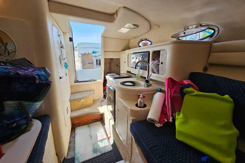 Slide: The Image of Interior of 2001 Sea Ray 260 Sundancer boat with kitchenette and seating area. - 19