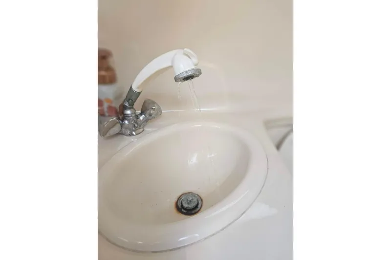 Slide: The Image of A white sink with a running faucet, indoors, close-up view. - 22