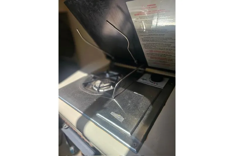 Slide: The Image of Stove inside 2001 Sea Ray 260 Sundancer boat, with open lid and burner. - 24