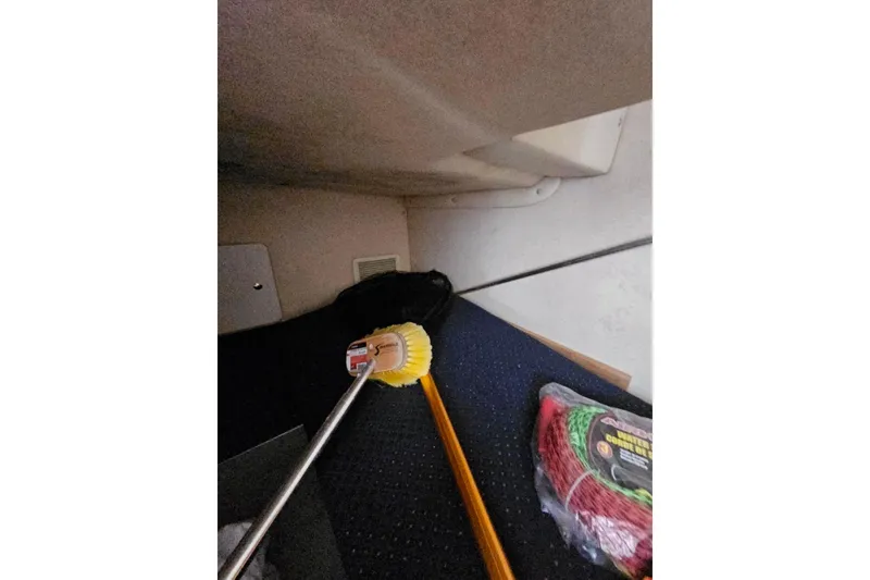 Slide: The Image of Interior of a 2001 Sea Ray 260 Sundancer with cleaning tools and coiled rope. - 26