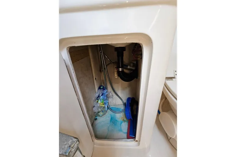 Slide: The Image of Storage compartment in 2001 Sea Ray 260 Sundancer boat, containing cleaning supplies. - 29