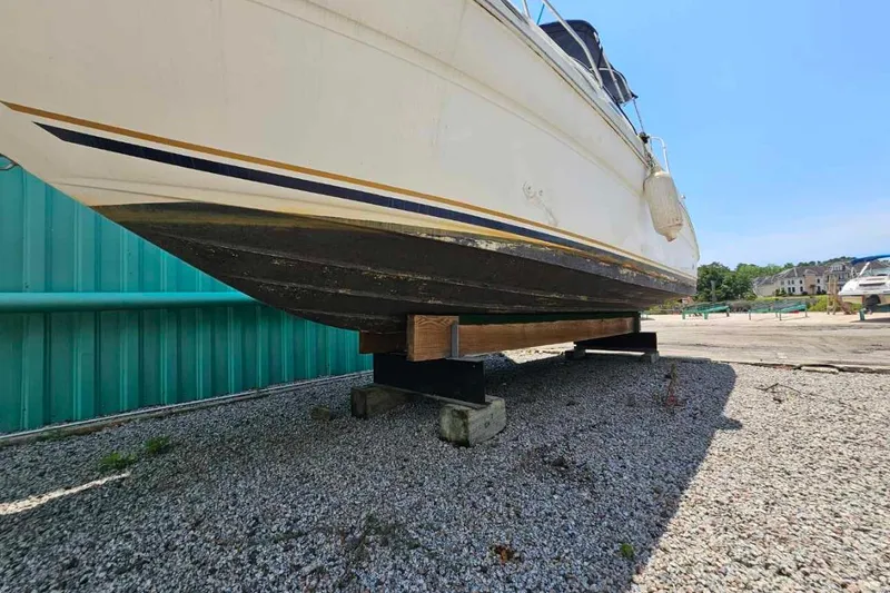 Slide: The Image of 2001 Sea Ray 260 Sundancer boat on dry dock, gravel ground, sunny day. - 3