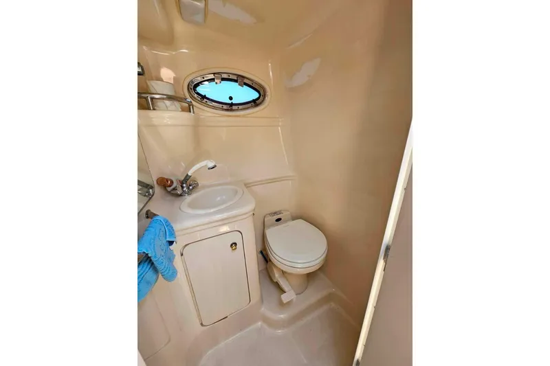 Slide: The Image of 2001 Sea Ray 260 Sundancer bathroom with sink, toilet, and porthole window. - 31