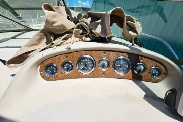 Slide: The Image of Dashboard of a 2001 Sea Ray 260 Sundancer boat with gauges and canvas cover. - 32