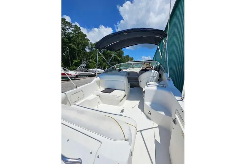 Slide: The Image of 2001 Sea Ray 260 Sundancer boat with canopy, docked under blue sky. - 33