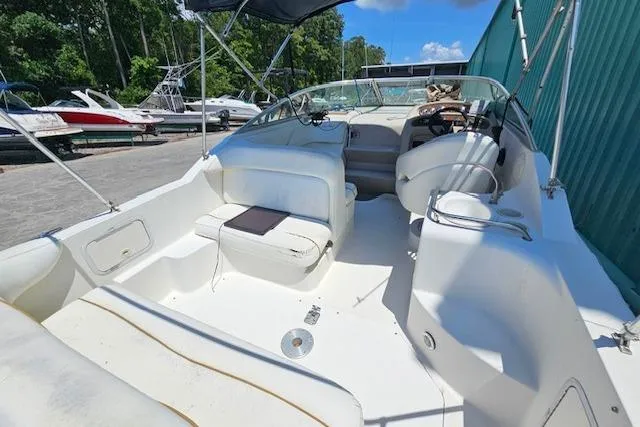 Slide: The Image of 2001 Sea Ray 260 Sundancer boat interior with seating, docked near other boats. - 35
