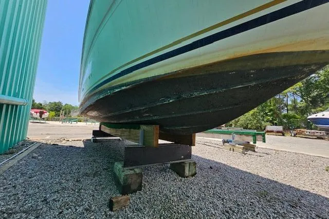 Slide: The Image of 2001 Sea Ray 260 Sundancer boat on blocks, showing hull and outdoor setting. - 4