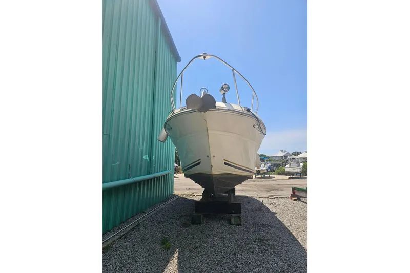 Slide: The Image of 2001 Sea Ray 260 Sundancer boat on dry dock beside a green building. - 6