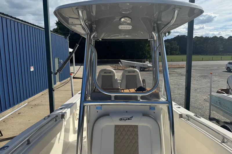 Slide: The Image of 2026 Bulls Bay 255 boat with T-top and seating, parked outdoors. - 13
