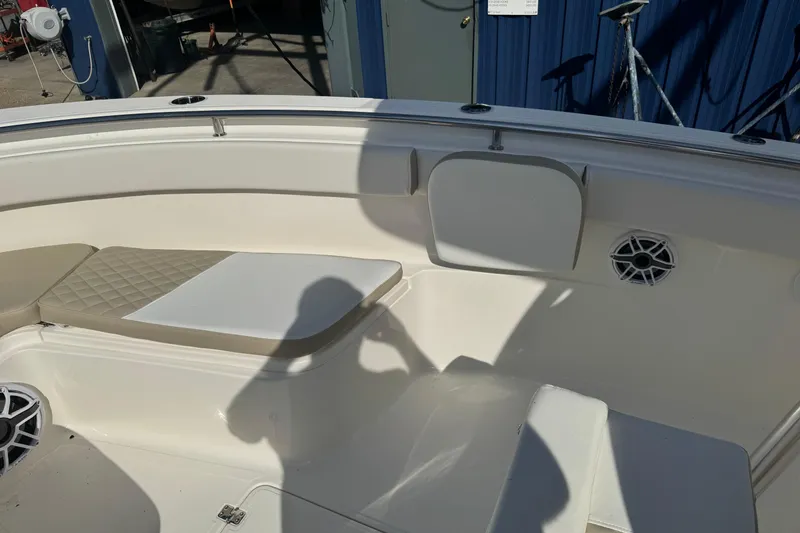 Slide: The Image of 2026 Bulls Bay 255 boat interior with seating and speaker, in a marina setting. - 14