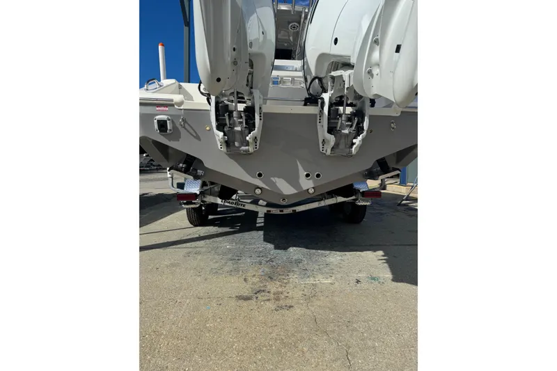 Slide: The Image of 2026 Bulls Bay 255 boat rear view with dual outboard motors on trailer. - 16