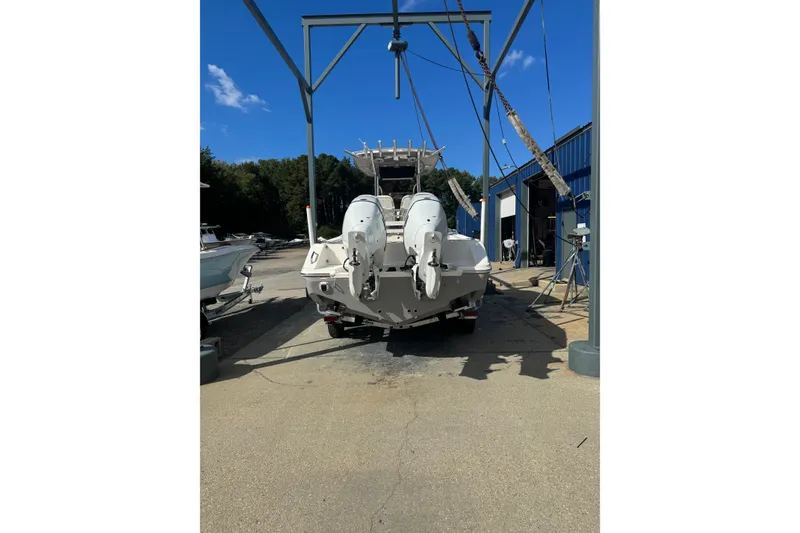 Slide: The Image of 2026 Bulls Bay 255 boat in a marina, rear view with dual engines. - 3