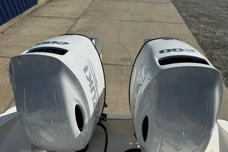 Slide: The Image of Twin Suzuki outboard engines on a 2026 Bulls Bay 255 boat, parked on concrete. - 4