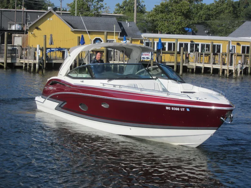 Slide: The Image of 2019 Formula 350 Crossover Bowrider cruising near a dockside restaurant. - 1