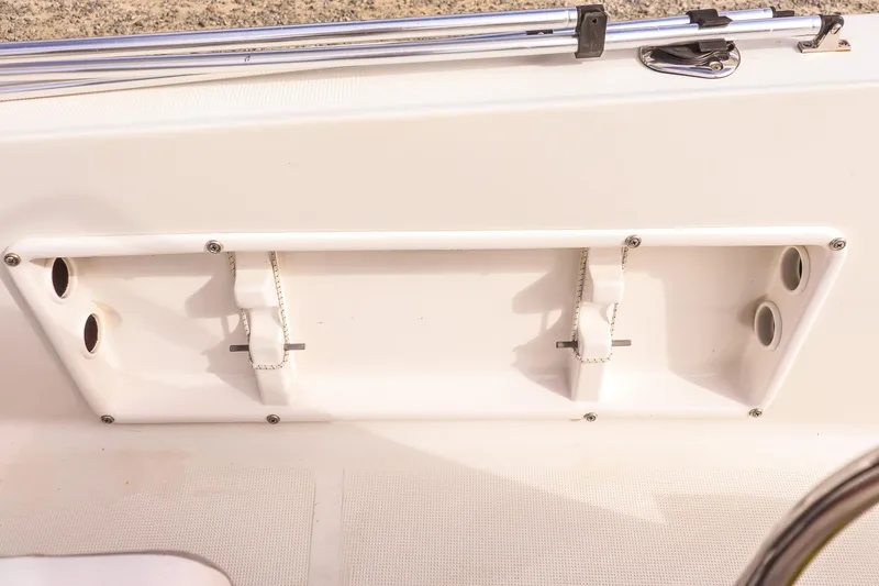 Slide: The Image of Key Largo 1800 Center Console 2020 boat interior detail with rod holders and storage compartment. - 11