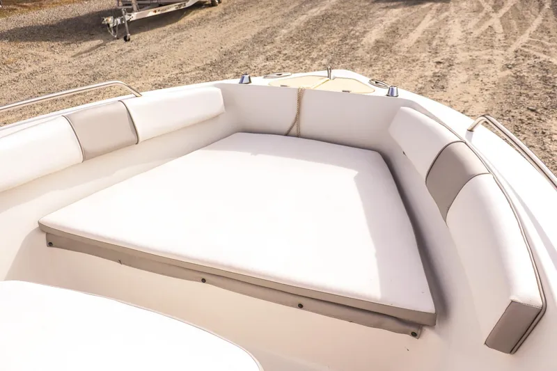Slide: The Image of 2020 Key Largo 1800 Center Console boat with cushioned seating, parked on gravel. - 16