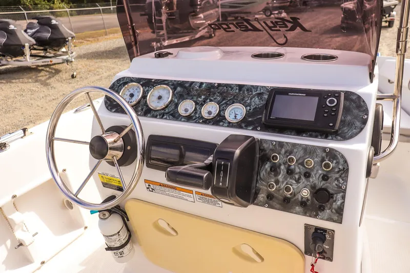 Slide: The Image of Key Largo 1800 Center Console 2020 dashboard with steering wheel and navigation controls. - 17