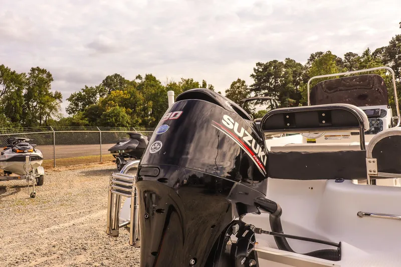 Slide: The Image of 2020 Key Largo 1800 Center Console boat with Suzuki outboard motor in a parking area. - 18