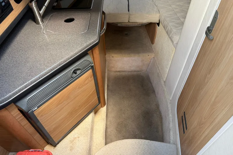 Slide: The Image of 2006 Sea Ray 270 Amberjack cabin interior with kitchenette and sleeping area. - 25