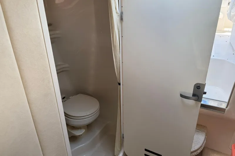 Slide: The Image of 2006 Sea Ray 270 Amberjack boat bathroom interior with toilet and door. - 31