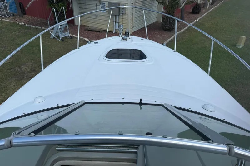 Slide: The Image of 2006 Sea Ray 270 Amberjack boat deck with railing and hatch, docked near garden. - 4