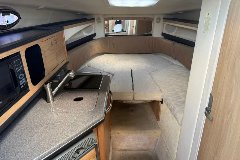 Slide: The Image of 2006 Sea Ray 270 Amberjack cabin interior with kitchenette and sleeping area. - 5