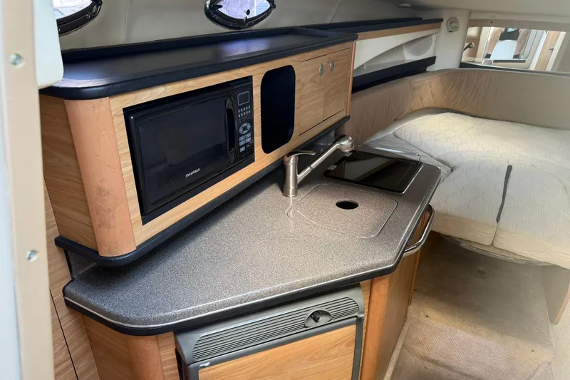 Slide: The Image of 2006 Sea Ray 270 Amberjack cabin interior with kitchenette and bed. - 52