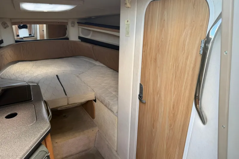 Slide: The Image of 2006 Sea Ray 270 Amberjack cabin interior with bed and kitchenette. - 53