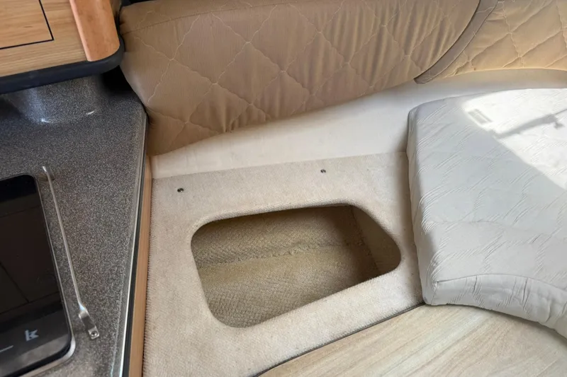 Slide: The Image of 2006 Sea Ray 270 Amberjack interior with storage compartment and cushioned seating. - 57