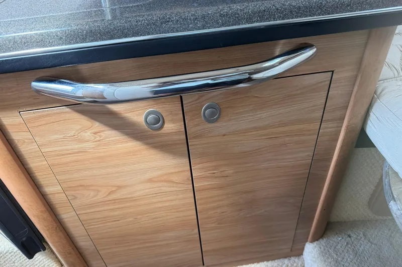 Slide: The Image of Wooden cabinet with chrome handle in 2006 Sea Ray 270 Amberjack boat interior. - 60