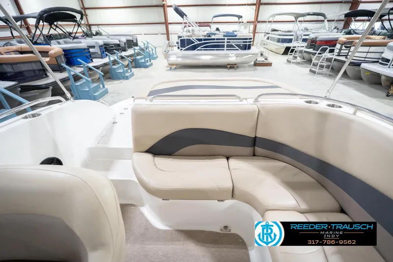 Slide: The Image of 2017 Hurricane SunDeck Sport 202 OB interior with beige seating in a showroom. - 21