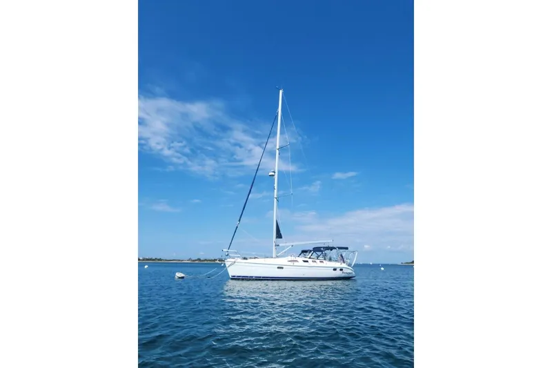 The Image of Sailboat Hunter 386, 2003 model, anchored on calm blue waters under clear sky. - 1