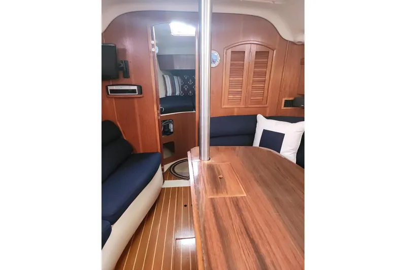 Slide: The Image of Interior of 2003 Hunter 386 sailboat with wooden finishes and navy seating. - 12
