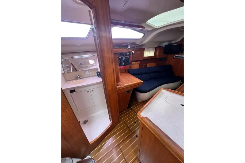 Slide: The Image of Interior of 2003 Hunter 386 sailboat with wood finish and compact living area. - 14