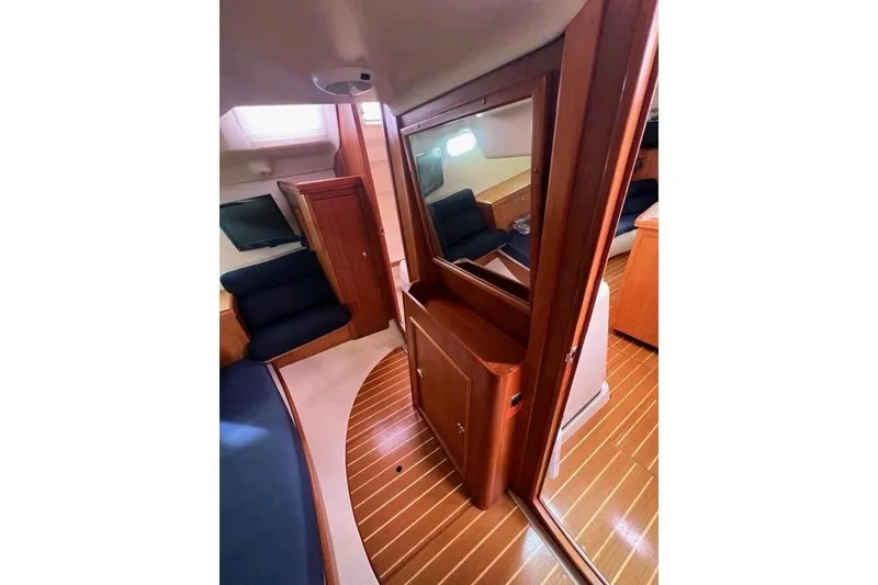 Slide: The Image of Interior of 2003 Hunter 386 sailboat with wooden finishes and blue seating. - 15