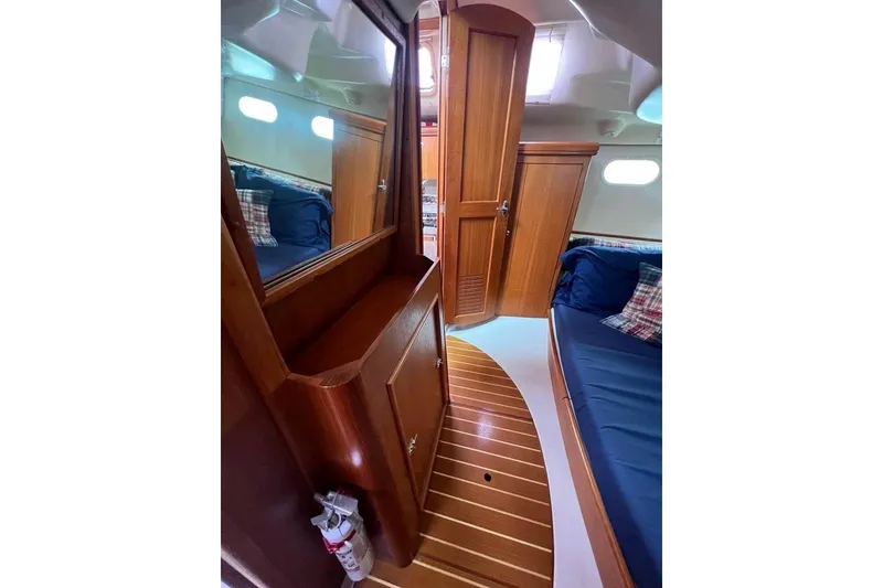 Slide: The Image of Interior of 2003 Hunter 386 sailboat with wooden cabinetry and blue seating. - 17